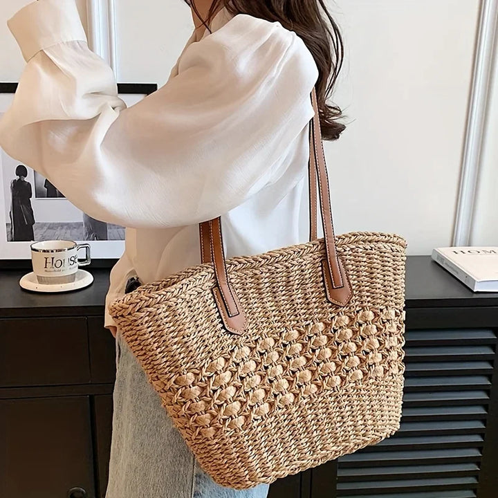 Woman carrying woven straw tote bag with leather straps, Rovelli fashion accessory