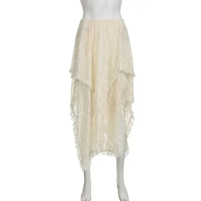 A cream-colored, silky lace asymmetrical skirt with a high waist, featuring a high-low hem, layered ruffles, and a sheer, flowy texture displayed on a white mannequin.