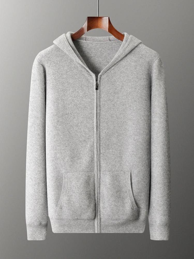 A light gray zip-up hoodie with a hood, front pockets, and ribbed cuffs and hem, displayed on a wooden hanger against a plain gray background—a cozy knit cardigan ideal for cool days.