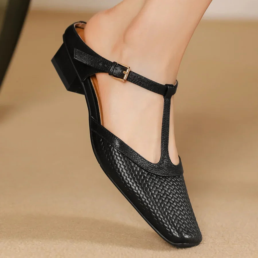 Rovelli black woven leather T-strap low heel shoe on foot, stylish women’s footwear