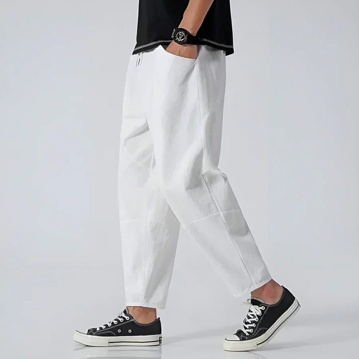 Rovelli casual white pants styled with black sneakers, side view on model