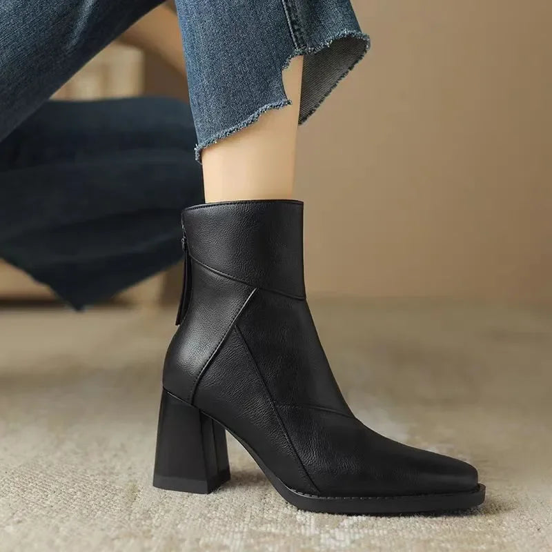 Rovelli black leather ankle boot with block heel and side zipper, styled with jeans