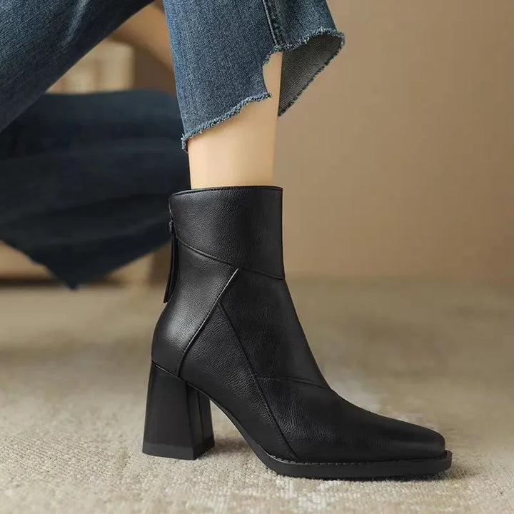 Rovelli black leather ankle boot with block heel and side zipper, styled with jeans