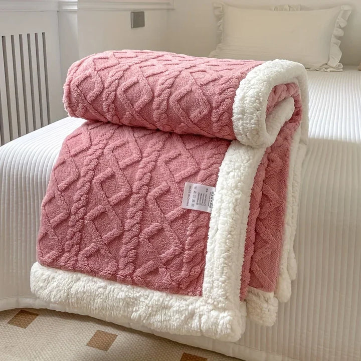 Rovelli pink textured blanket with white sherpa trim on a neatly made bed