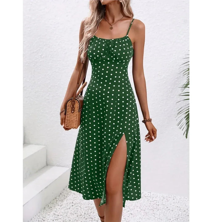 Woman in green polka dot sundress with side slit, holding woven bag, Rovelli fashion