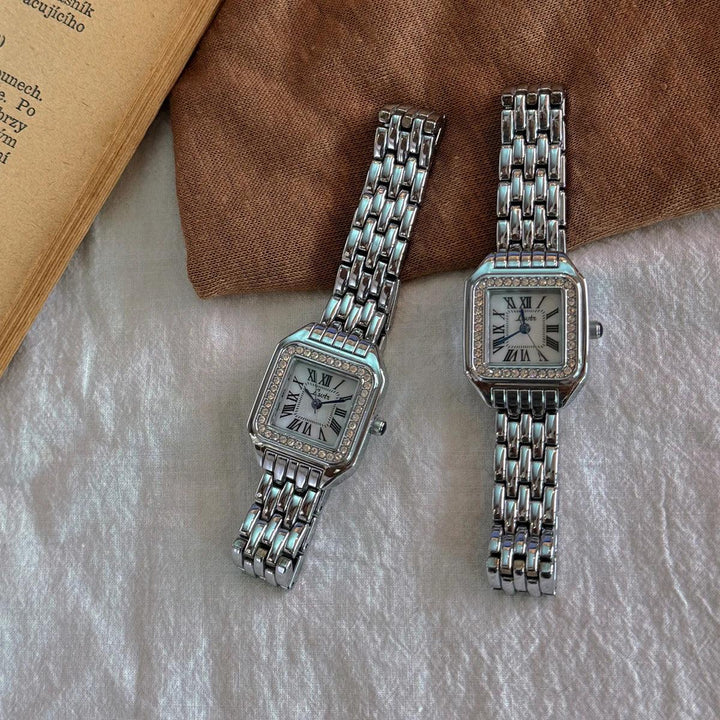 Rovelli silver square watches with Roman numeral dials on elegant fabric background