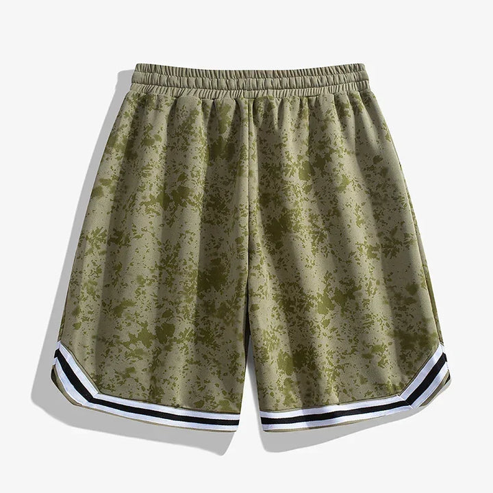 A pair of olive green Korean Edition Sports Shorts with a subtle splatter pattern, featuring a black and white striped trim at the hem and an elastic waistband, displayed on a plain white background.