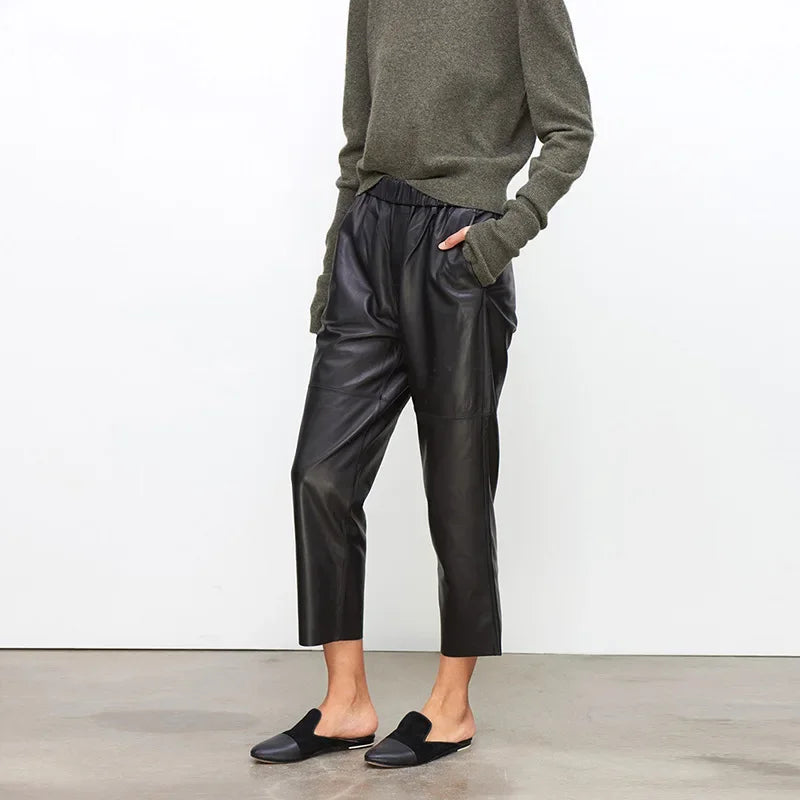 Rovelli model wearing black leather pants, olive sweater, and black slippers