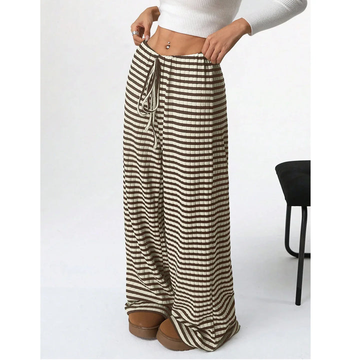 Woman wearing Rovelli brown and white striped wide-leg pants with drawstring waist