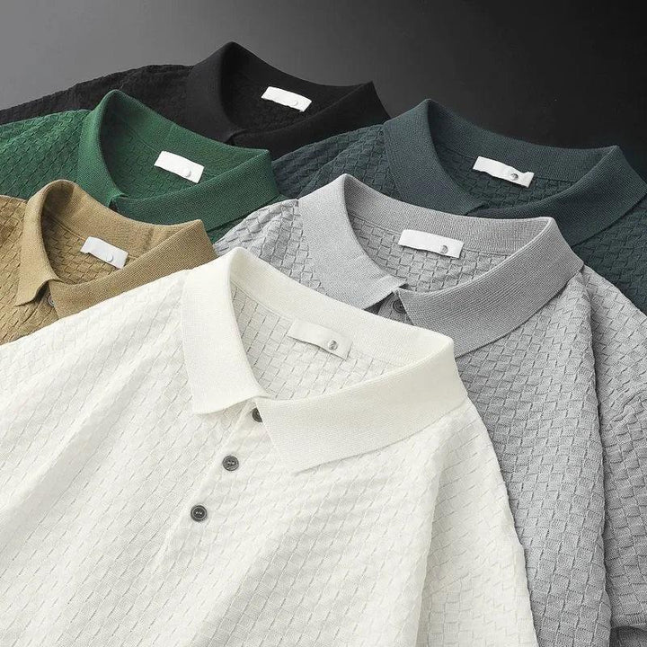 Six waffle jacquard polo shirts in white, beige, green, black, gray, and dark green are arranged in a fan-like pattern. Each features a collar and buttons, with the textured designs neatly overlapping on a flat surface.