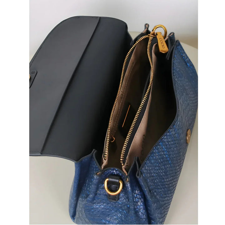 Rovelli blue textured handbag with gold zipper and open flap, showing interior compartments