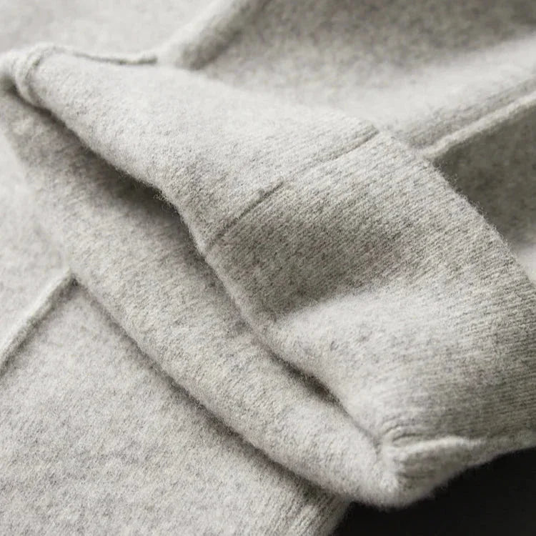 Close-up of soft, light gray fleece fabric showcasing its plush, textured surface and visible stitching, hinting at comfortable pants with durable construction perfect for everyday wear.