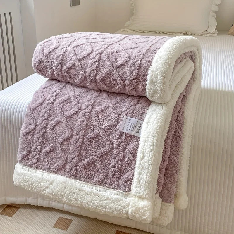 Soft mauve diamond-patterned sherpa blanket with white trim folded on a bed, Rovelli home decor