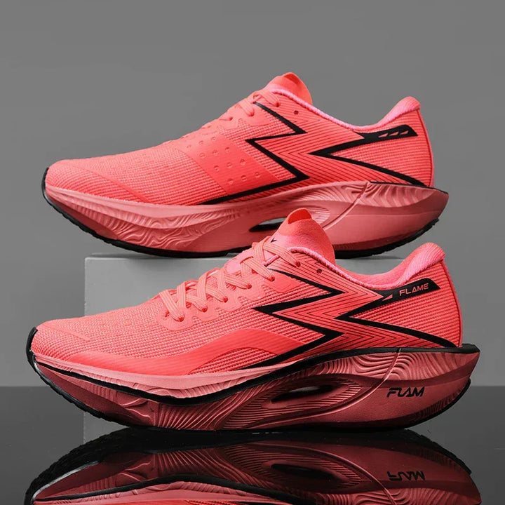 A pair of bright pink athletic running shoes with black zigzag stripes, featuring an ultra-lightweight, shock-absorbing sole, displayed side by side on a gray background with one shoe propped on a small block.