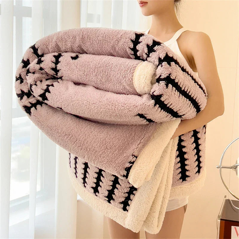 Woman holding large fluffy Rovelli blanket with soft pink and black stripe design