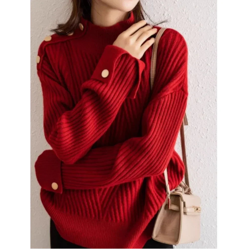 Woman wearing a red ribbed knit sweater with gold buttons, holding beige handbag, Rovelli