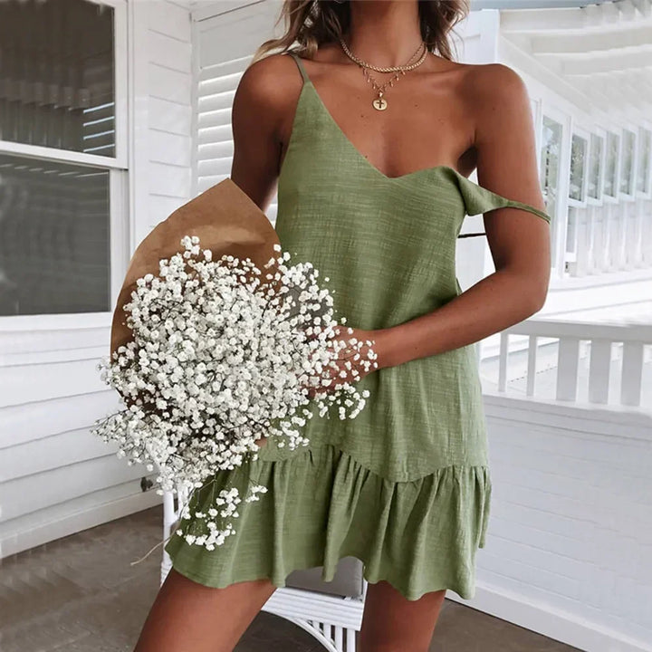 Woman in green sundress holding baby's breath bouquet on a white porch, Rovelli fashion