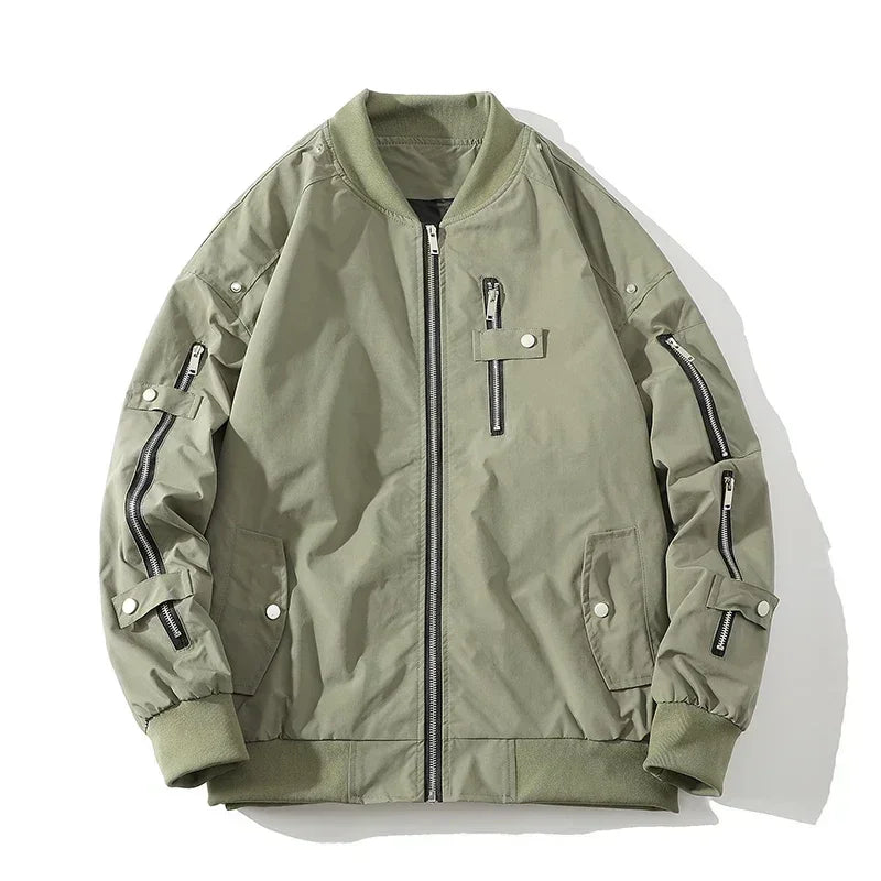 A light olive green bomber jacket with a ribbed collar, black zipper closures, zippered chest and sleeve pockets, buttoned side pockets, and ribbed cuffs and waistband, laid flat on a white background.