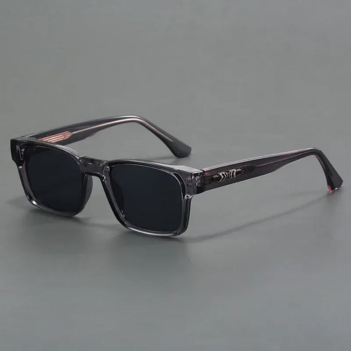 A pair of rectangular black sunglasses with dark lenses and durable, glossy translucent frames, featuring modern design and UV400 protection, displayed on a plain gray background.