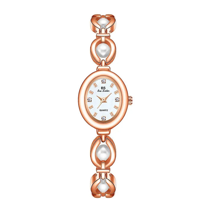 A rose gold women’s wristwatch with an oval white face, gold hands, and four crystal hour markers. The bracelet features decorative links with pearl accents and a precision quartz movement for reliable timekeeping.
