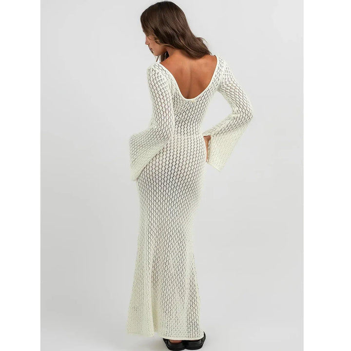 Woman wearing long white crochet open-back dress with flared sleeves, Rovelli fashion