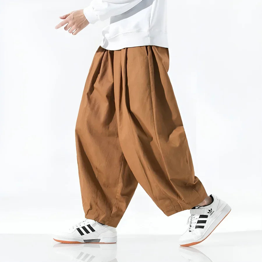 Rovelli wide leg brown pants styled with white sweater and sneakers, side view