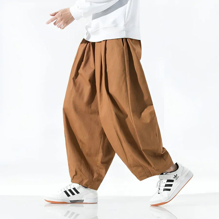 Rovelli wide leg brown pants styled with white sweater and sneakers, side view