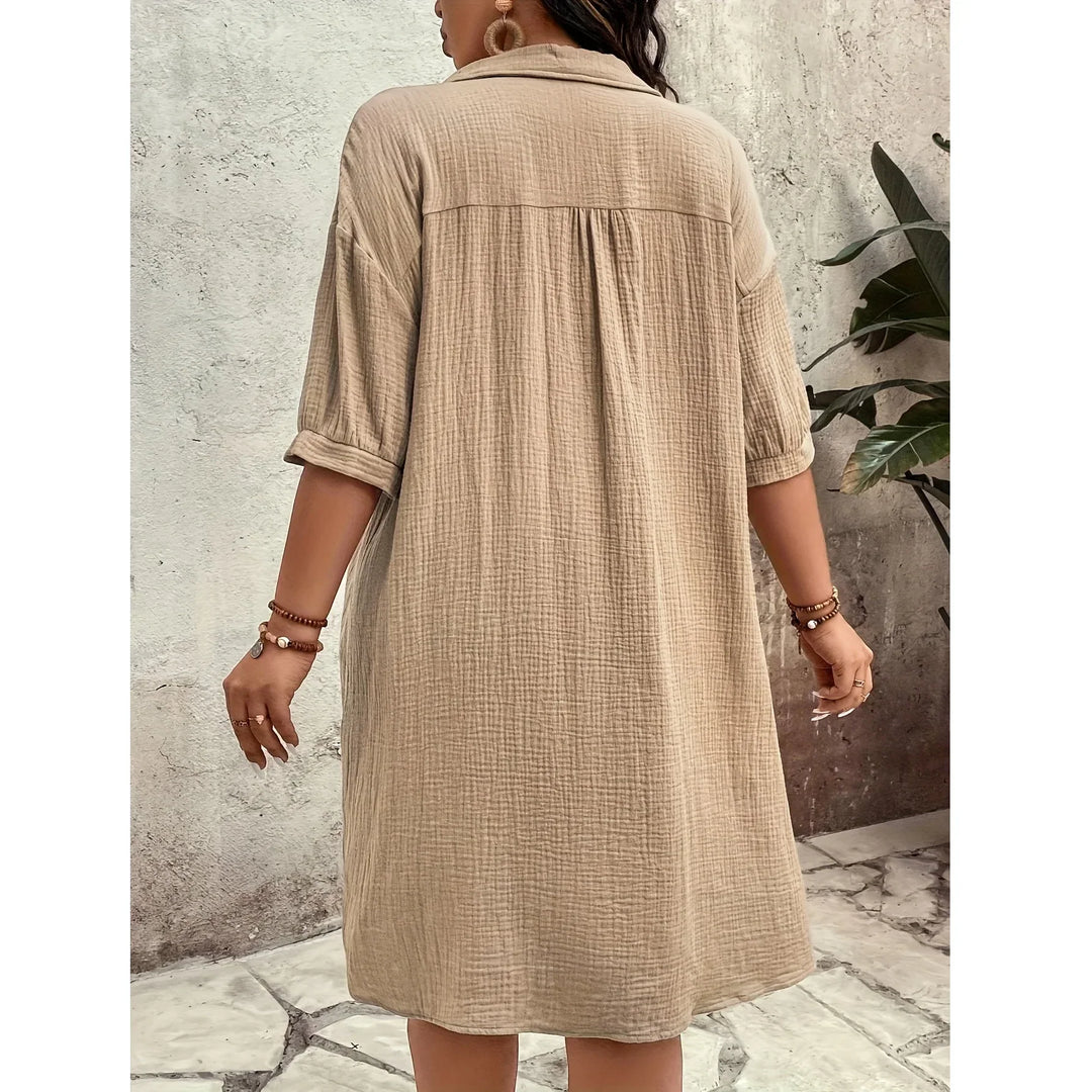 Back view of a woman in a beige textured shirt dress from Rovelli, standing outdoors