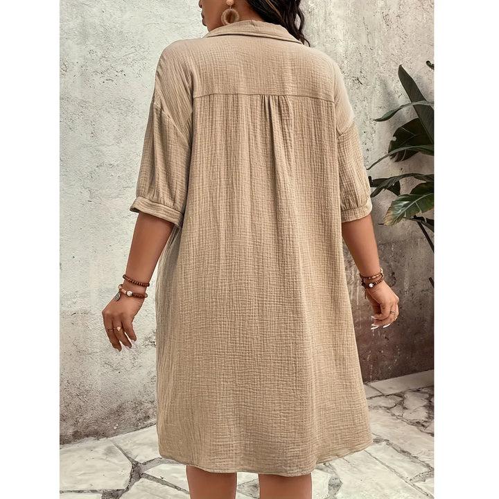 Back view of a woman in a beige textured shirt dress from Rovelli, standing outdoors
