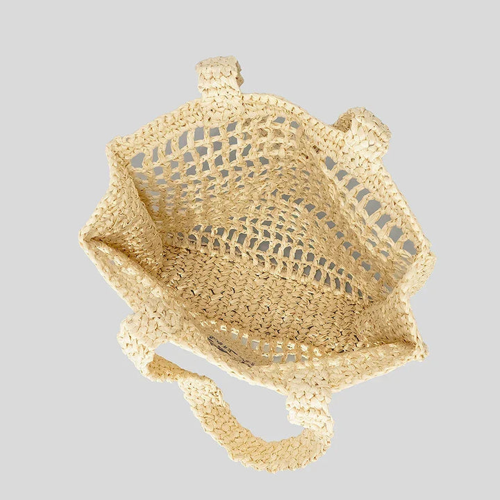 Rovelli woven straw tote bag with open mesh design and handles on light gray background