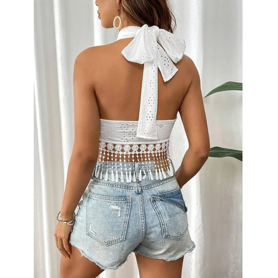 Back view of woman in a Rovelli white lace crop top with bow and denim shorts, casual style