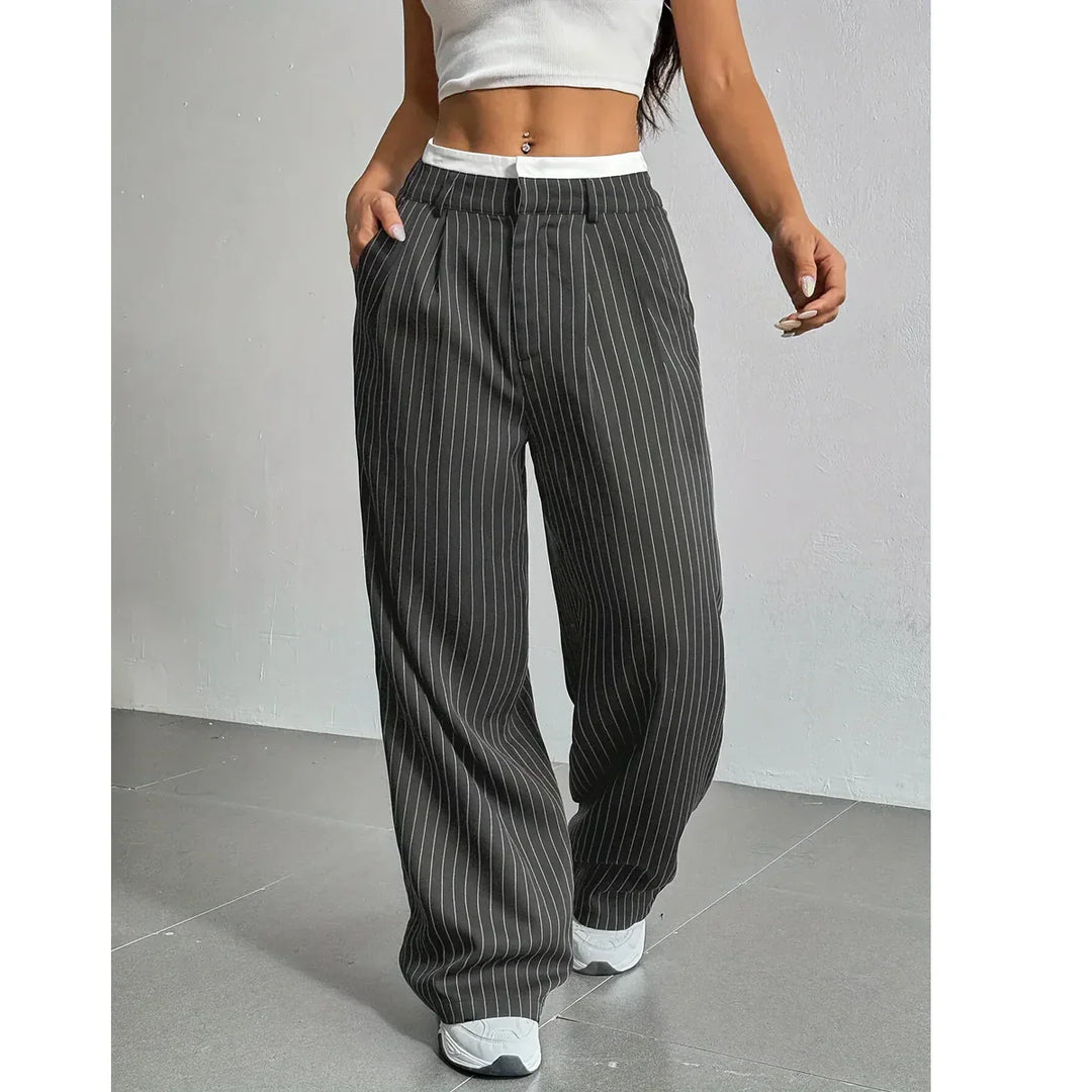 Woman wearing black pinstripe wide-leg trousers and white crop top, Rovelli fashion