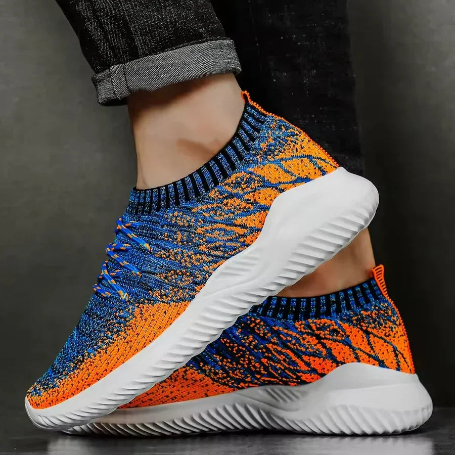 Rovelli blue and orange knit sneakers with white soles, worn with rolled-up jeans