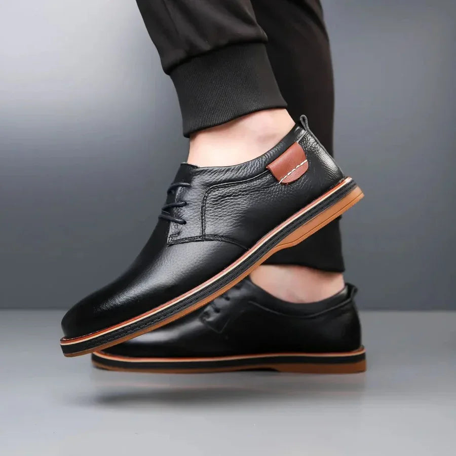 Rovelli black leather men’s dress shoes with brown sole and accent, worn with black pants