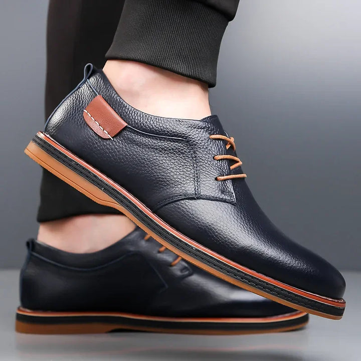 Rovelli navy blue leather dress shoes with brown laces and tan sole, worn with black pants