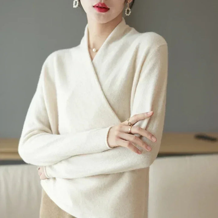 Woman wearing cream wrap sweater, pearl earrings and rings, Rovelli fashion style