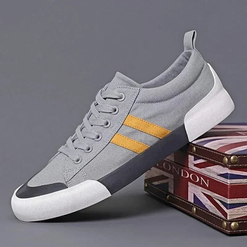 Rovelli grey canvas sneaker with yellow stripes, white sole, displayed on Union Jack box