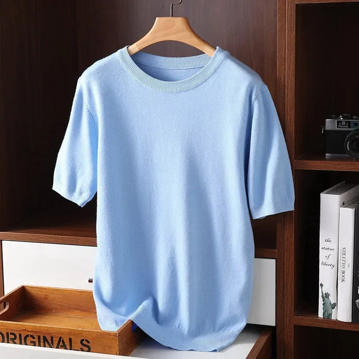 Light blue short sleeve knit sweater on hanger, Rovelli clothing, wooden shelf background