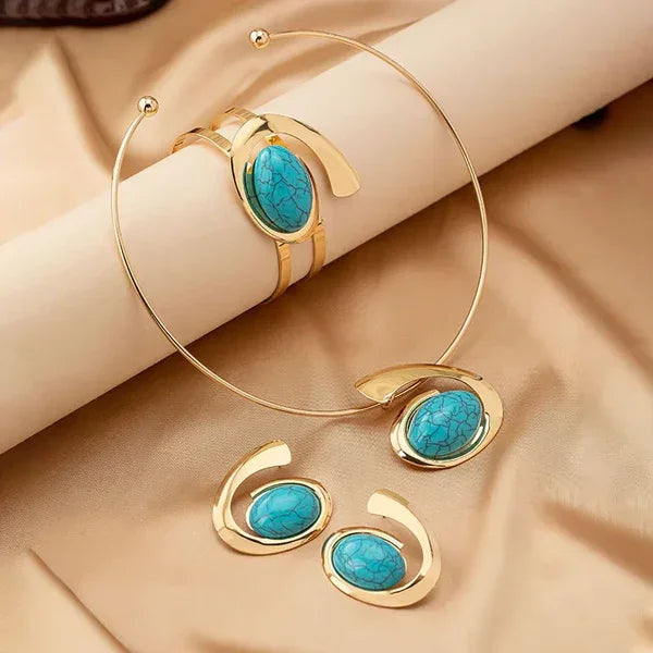 Rovelli gold jewelry set with turquoise stones on beige fabric background