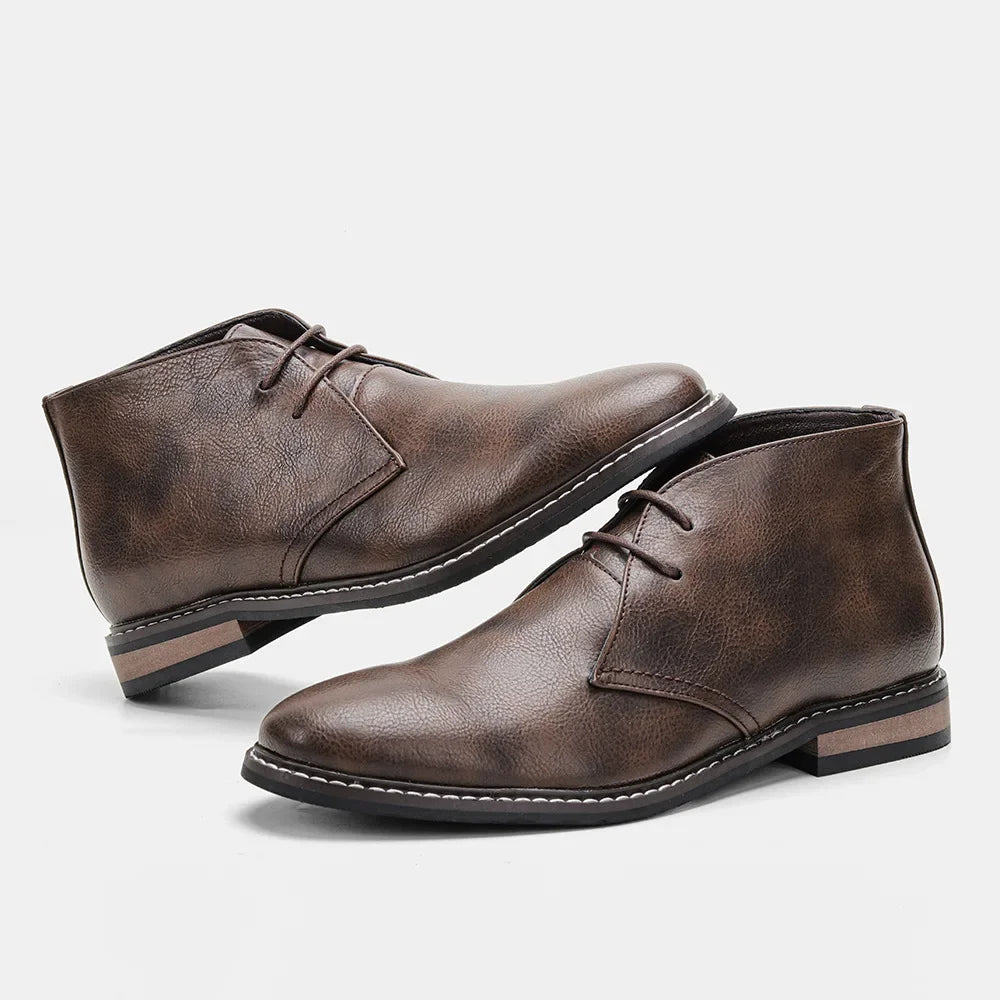 A pair of brown leather After-Ride Chukka boots with a low heel and black rubber sole, featuring a Western-inspired chukka silhouette, displayed against a plain white background.