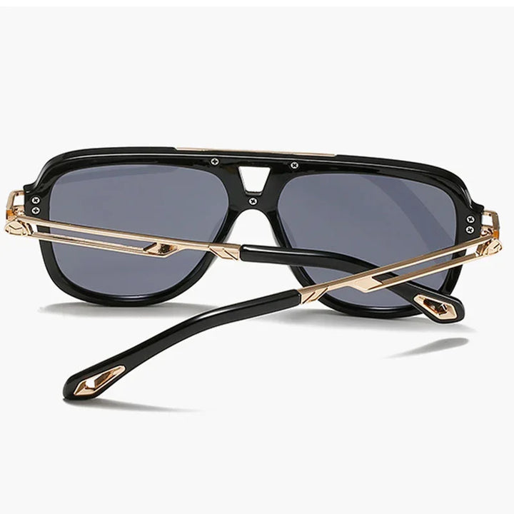 A pair of black vintage sunglasses with gold accents, shown from the back with crossed temples and dark tinted lenses, against a plain white background.