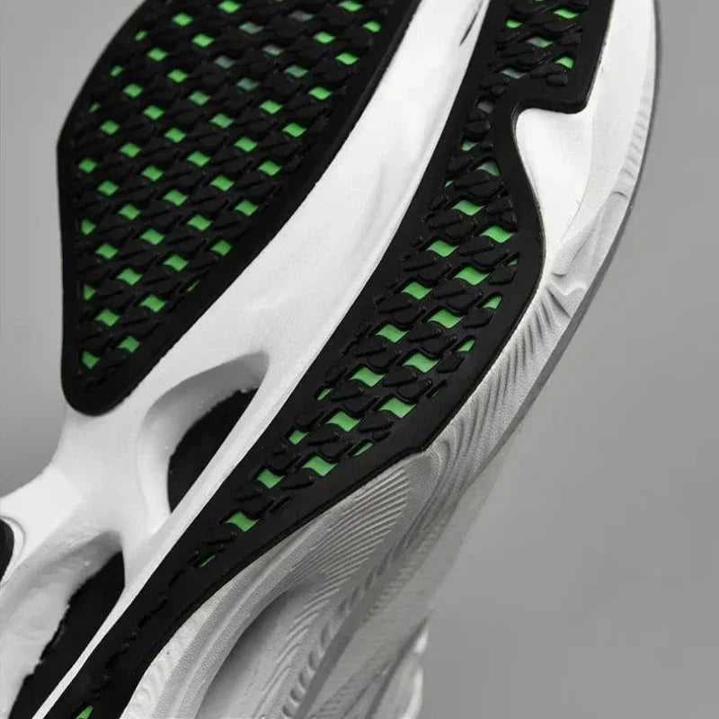 Close-up of the sole of a white sneaker with black and green tread pattern, featuring a textured, ultra-lightweight design for grip and style. The non-slip outsole adds stability for confident steps.