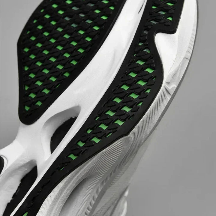 Close-up of the sole of a white sneaker with black and green tread pattern, featuring a textured, ultra-lightweight design for grip and style. The non-slip outsole adds stability for confident steps.