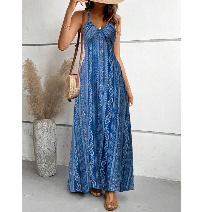 Woman in blue bohemian maxi dress and straw hat, holding wicker bag, Rovelli fashion