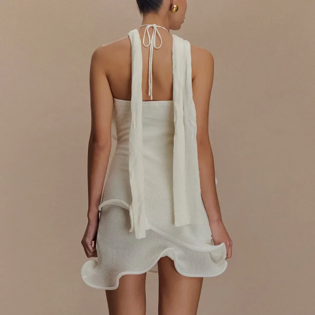 Back view of woman in a white halter mini dress with ruffle hem, Rovelli fashion