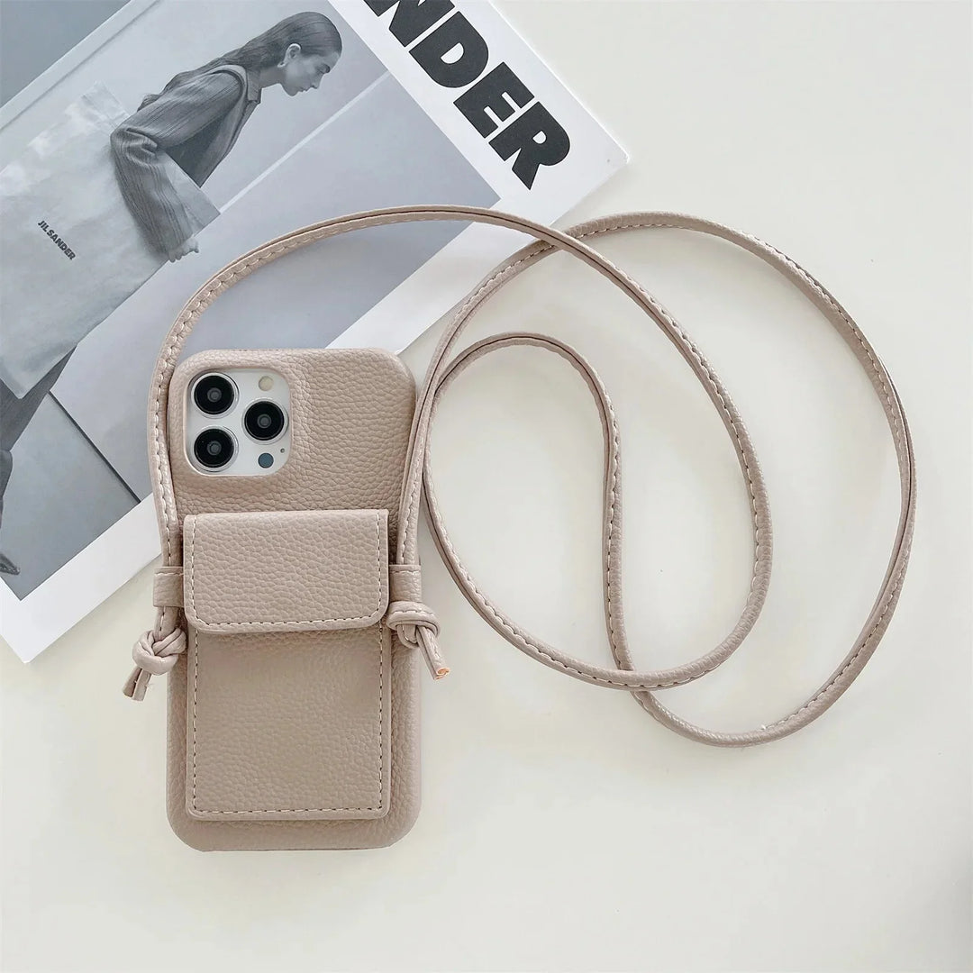 A beige leather phone case with a small pouch and detachable lanyard rests atop a magazine featuring a black-and-white photo of a person holding a tote bag.