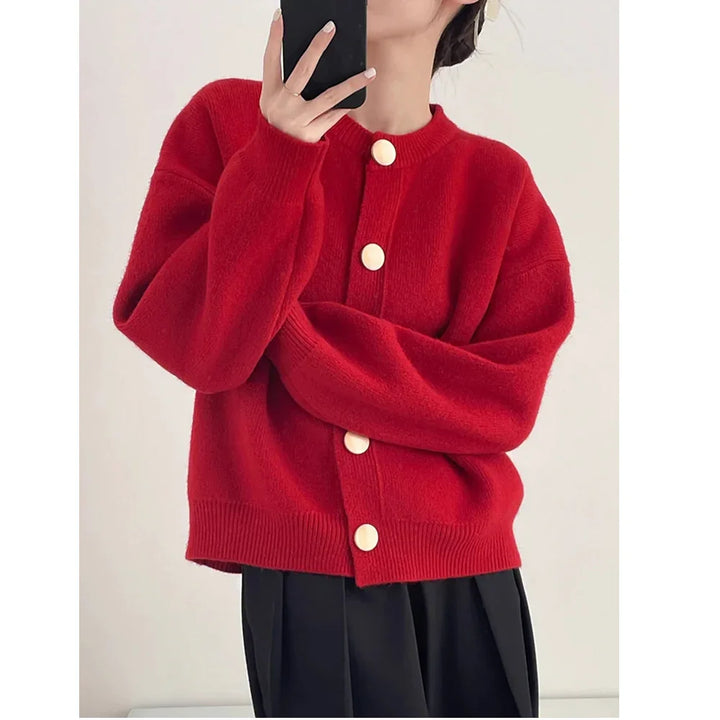 Rovelli red knit cardigan with large white buttons, worn by a woman taking a selfie
