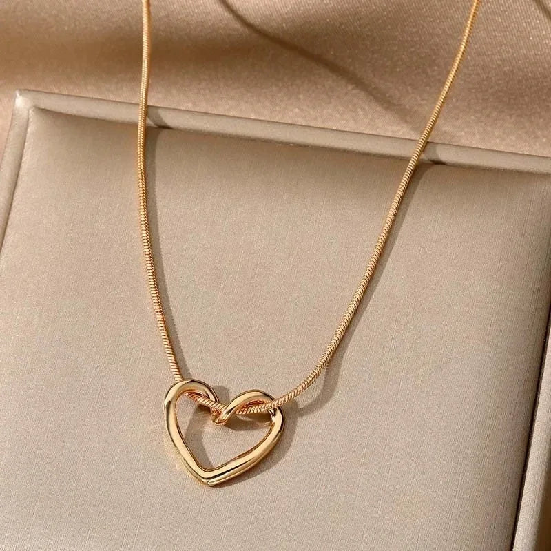 Rovelli gold heart pendant necklace on beige display background
