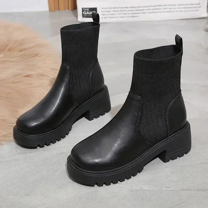 Rovelli black chunky ankle boots with ribbed knit sock detail on gray floor