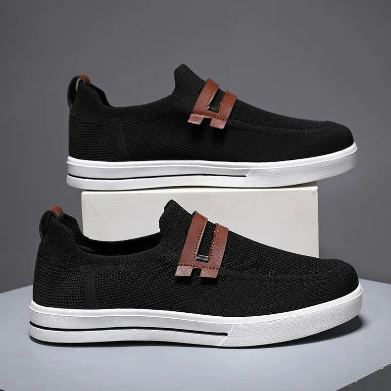 Rovelli black slip-on sneakers with brown accents and white sole on display